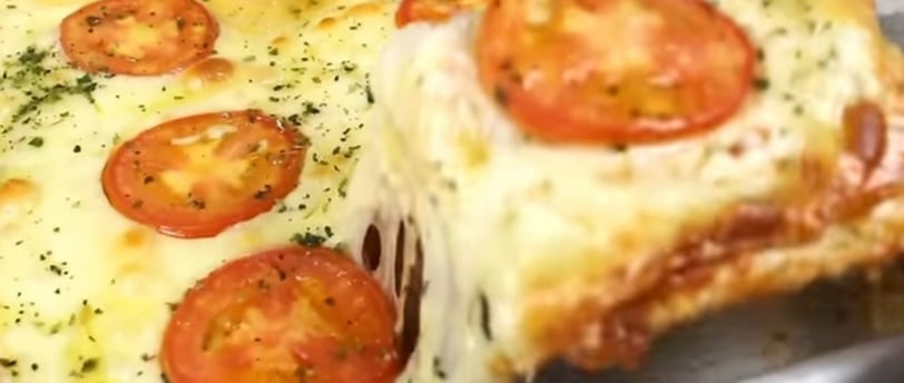 Pizza de pão de forma, quentinha, recém tirada do forno, coberta de azeite e orégano e com queijo de