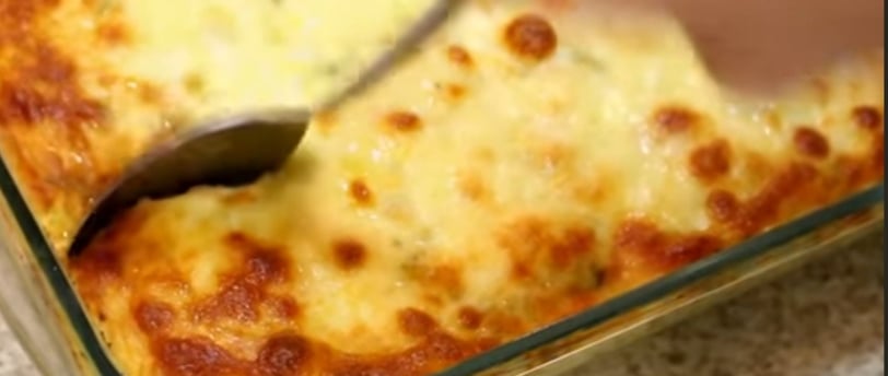   Imagem de um arroz de forno com mussarela, com uma textura cremosa e derretida. O arroz está num r