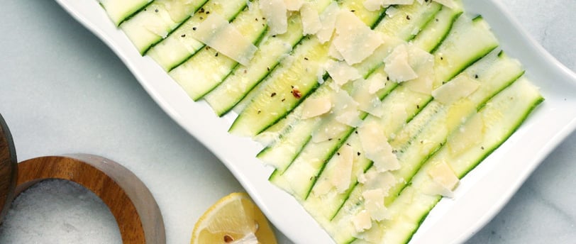 Un plato rectangular blanco con un carpaccio de calabacín