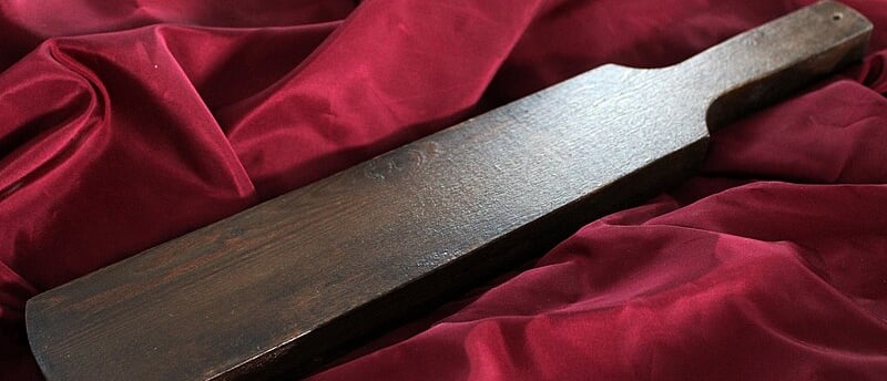 a wooden cutting board spanking paddle
