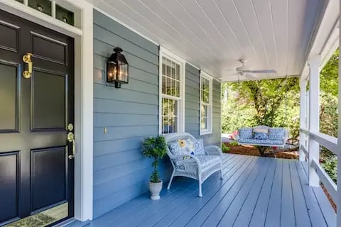 Blue house exterior with white trim and a cozy porch, showcasing Camas Painters, your trusted house painter.