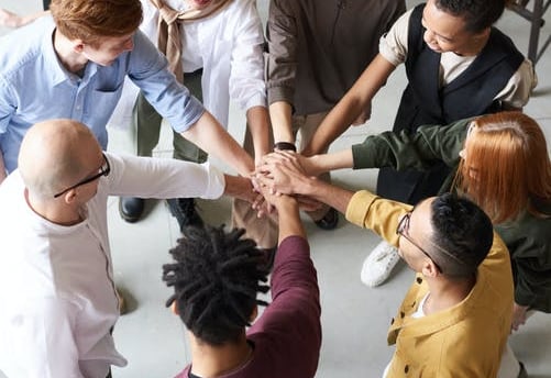 a group of people holding hands in a circle at AA meeting