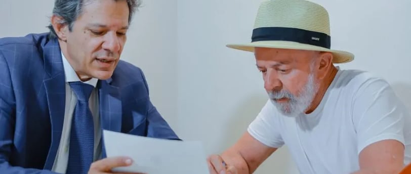 Presidente Lula de chapéu sentado à mesa