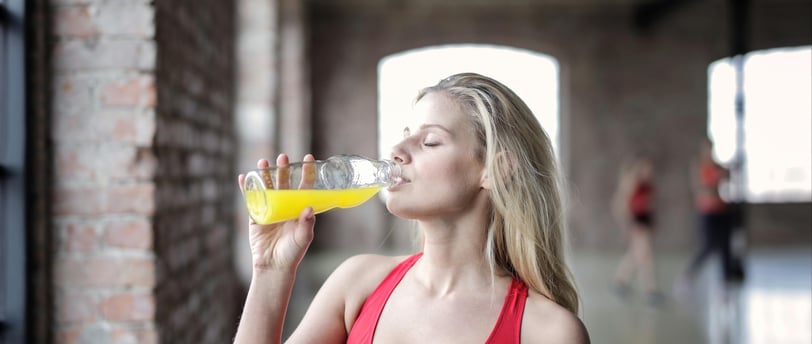 une femme boit une boisson énergisante après le sport