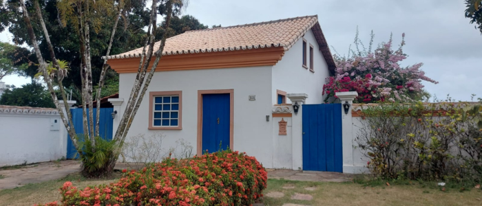 Imagem de uma casa branca com portas azuis