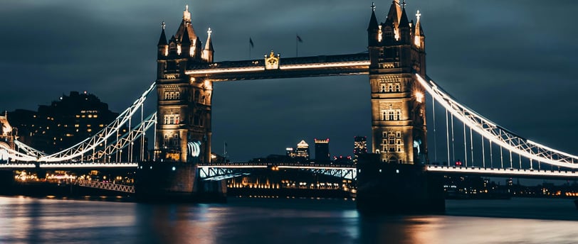 Illuminated Tower Bridge reflecting on the River Thames at night in London