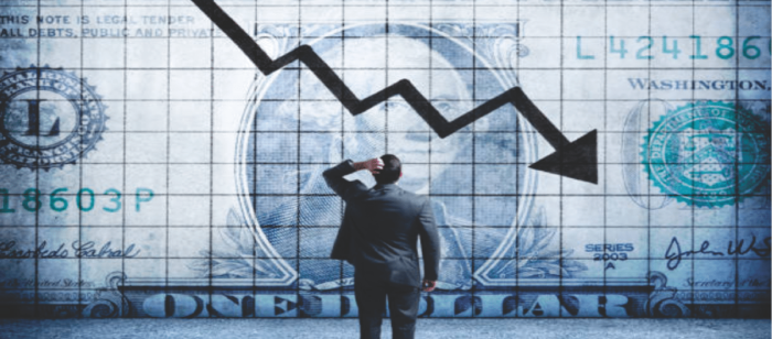 man in business suit facing a large dollar bill with down arrow