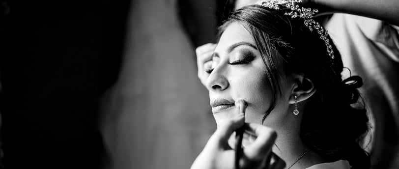 a woman getting her makeup done by a professional makeup artist