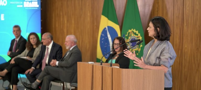 a woman in a suit and tie is standing at a podium