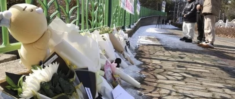 a teddy bear is placed on a fenced in area