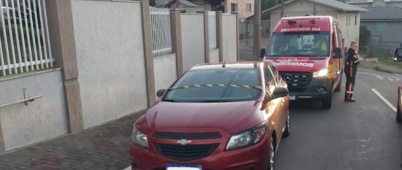 a red car is parked on the side of a street