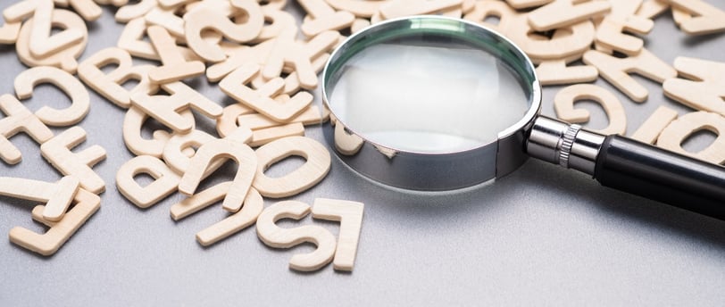 a magnifying glass amongst a jumble of letters