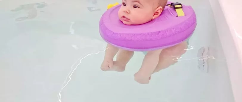 a baby in a tubtub with a purple float ring