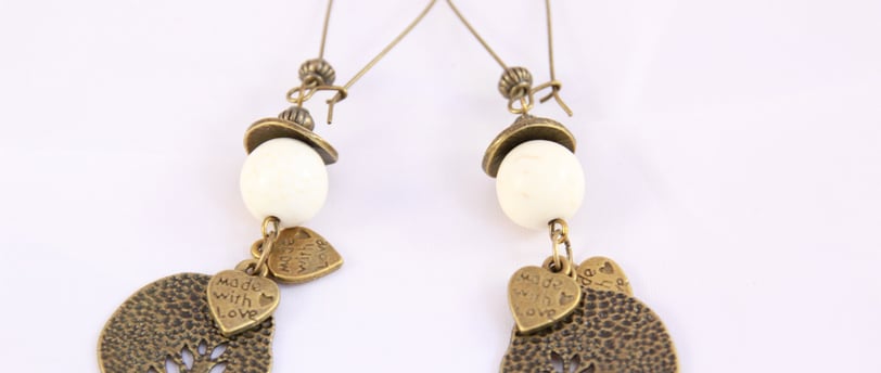 a pair of earrings with a bird on it