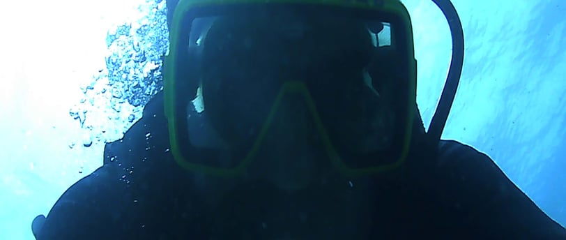 a person wearing a scuba suit and a scuba mask for night dive in lovina reef