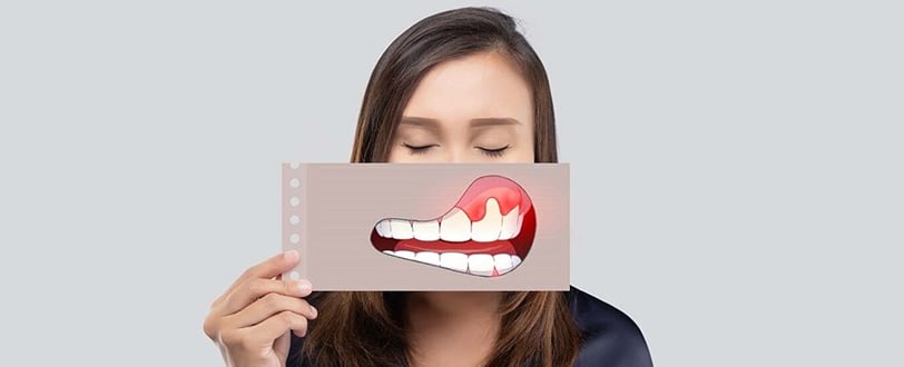 a woman holding a card with a painful smile