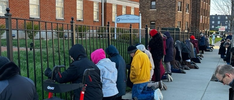 A group of people peacefully praying in front of planned parenthood
