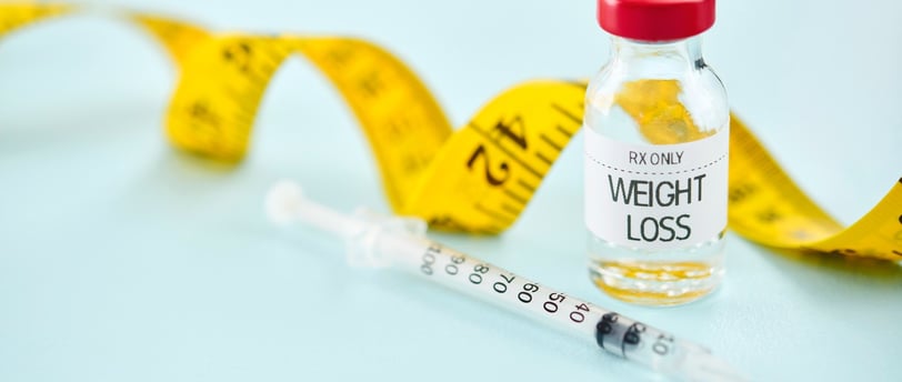weight loss drug and tape measure