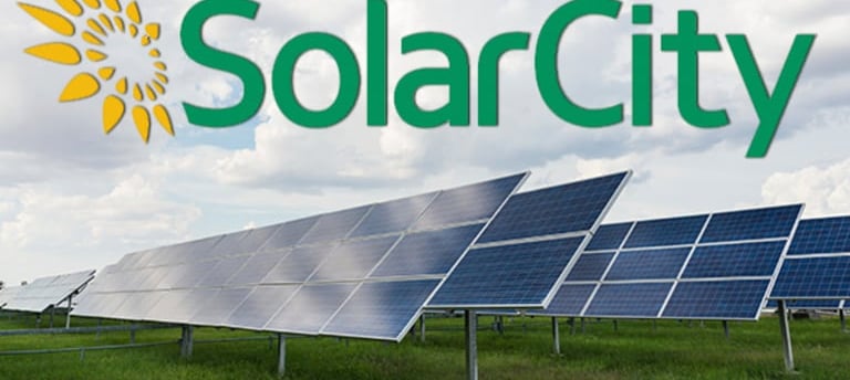Solar City Logo Above Rows of Ground mounted solar panels.