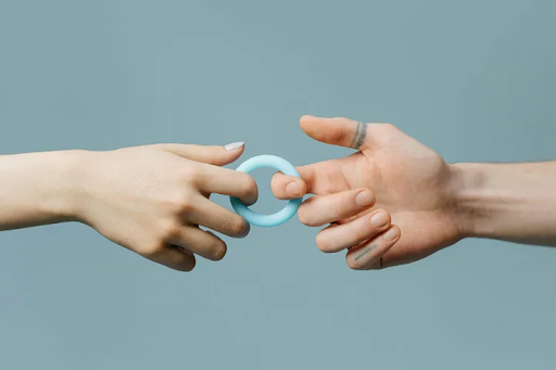 male and female hands connected by a ring