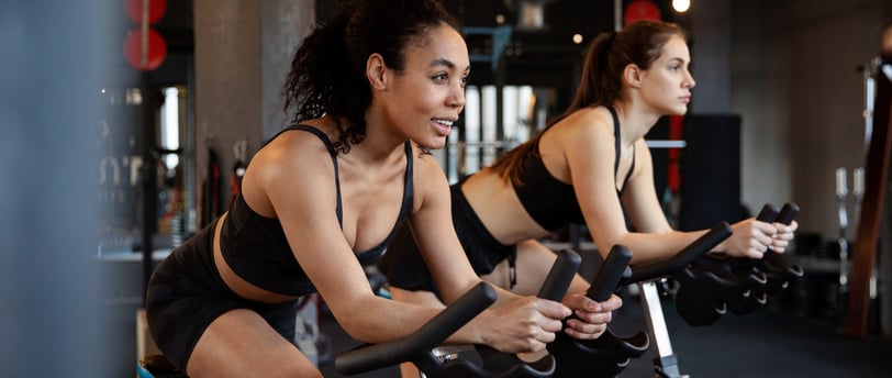 a woman is riding a stationary bike in a gym
