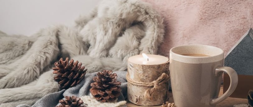 a cup of coffee and a candle on a table