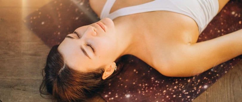 a woman is laying on a yoga mat