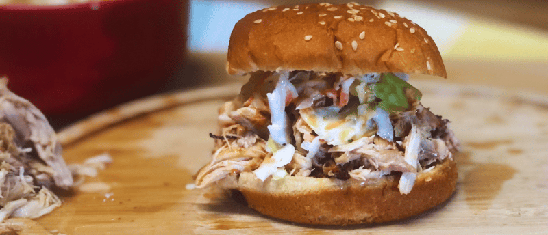 Carolina pulled chicken with coleslaw and hotsauce on a cutting board