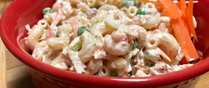 Chilled tuna pasta salad with carrots in a red serving bowl, simple and budget-friendly meal