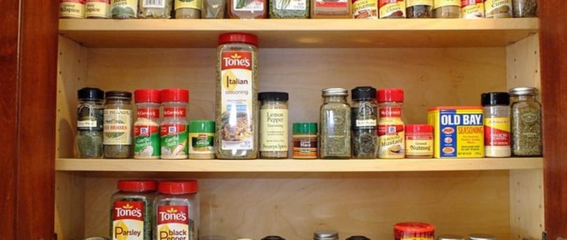 a large variety of spices in the kitchen cabinet.
