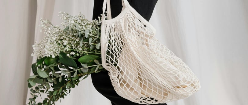 a woman holding a net net baguet bag