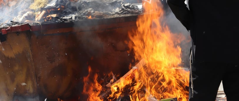 A man standing in front of a burning trash