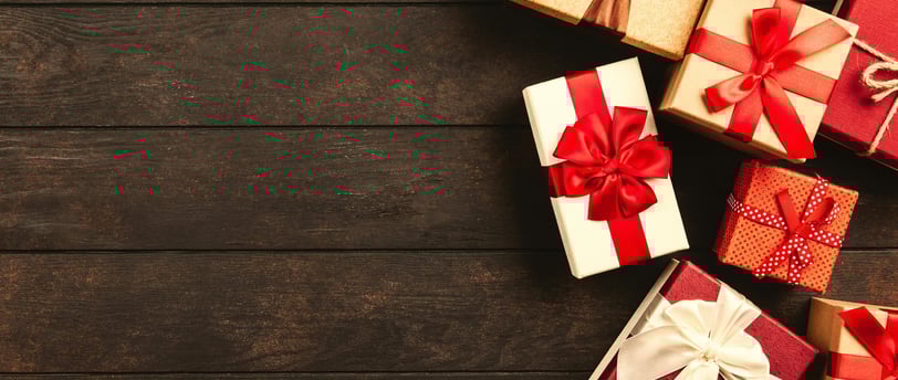 a bunch of gift boxes with bows on a wooden table