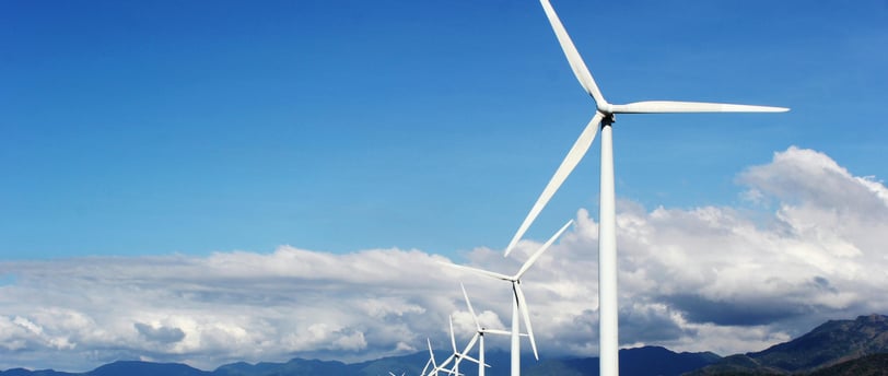a wind turbine on a beach with a blue sky