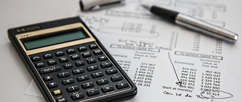 a calculator and pen on a paper with a pen