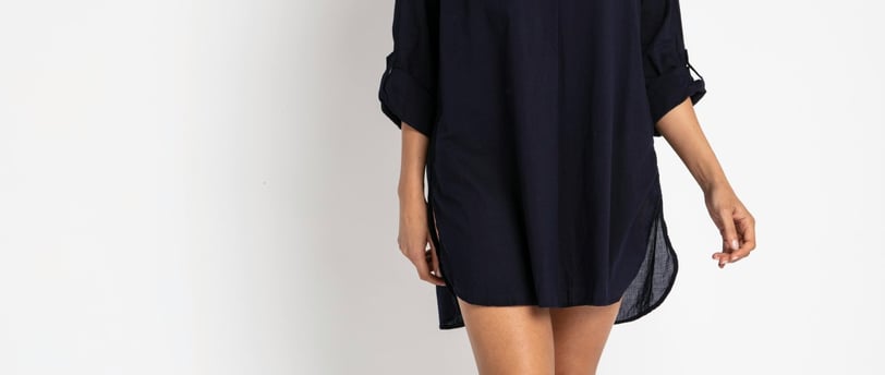 a woman in a short dress standing in front of a white wall