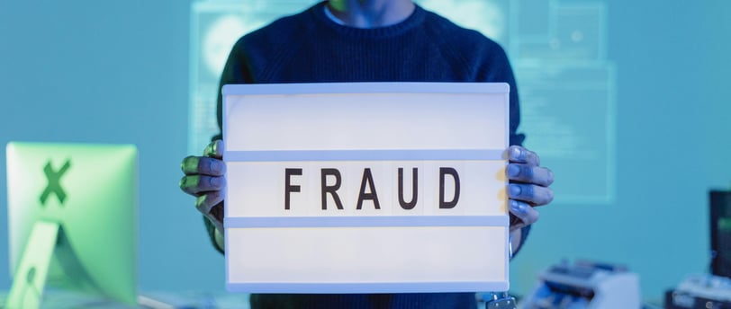 a man holding a sign that says fraud
