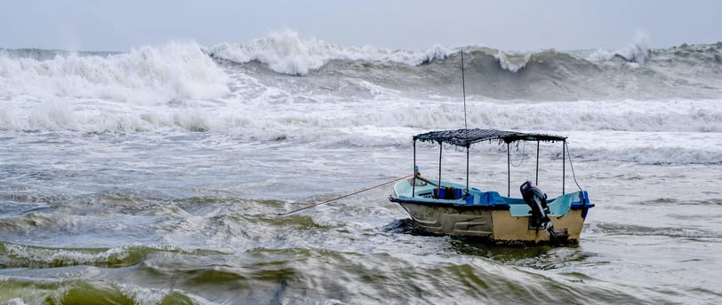 A ship anchored in with large waves incoming.