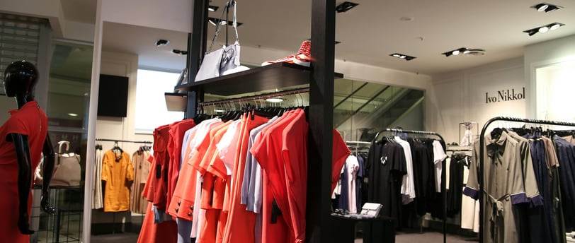 a fashion shop with dresses, outfits and coats on display