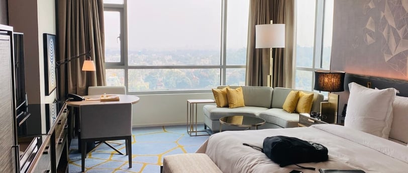 A hotel room with a couch and a television used for a blog titled AI hotel marketing