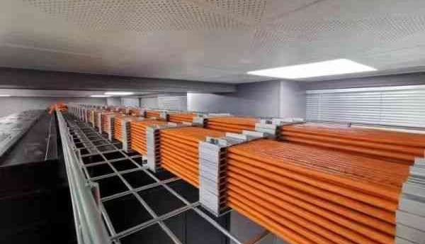 a long row of orange cables on the wire mesh cable tray