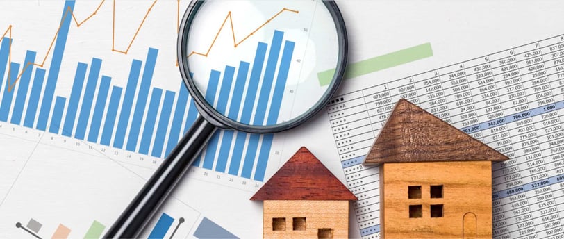 Lupa em cima de gráficos e planilhas de uma avaliação de imóvel para locação.