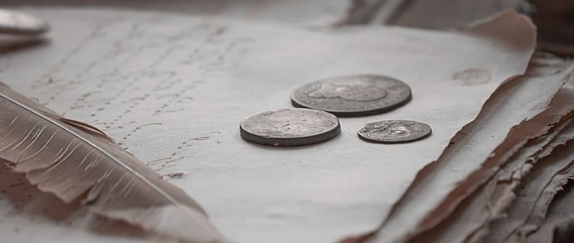 a stack of coins and a pen on a table