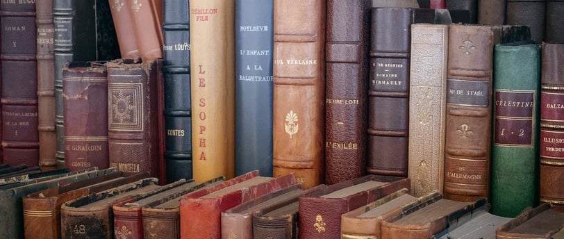a bunch of books on a shelf in a bookcase