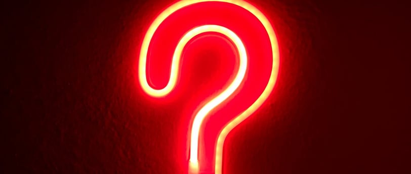 a neon - lit sign with a question mark on it