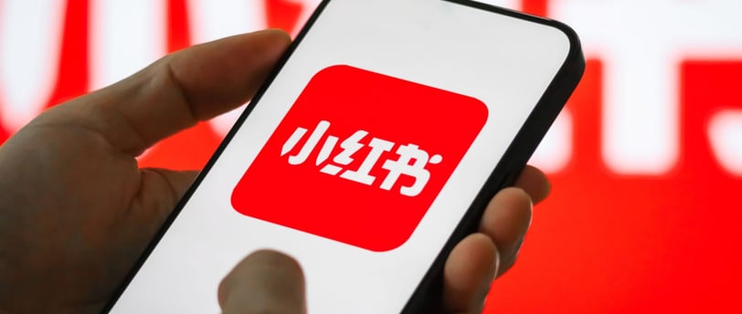 a person holding a phone with a red and white sign