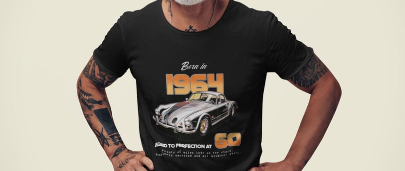 A man wearing a 'Born in 1964' t-shirt stands with his hands on his hips in a casual pose, smiling