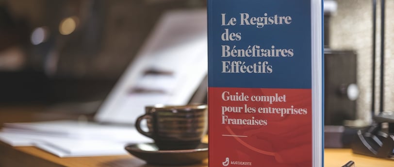 a book on a table with a cup of coffee and a pen LEGALIS