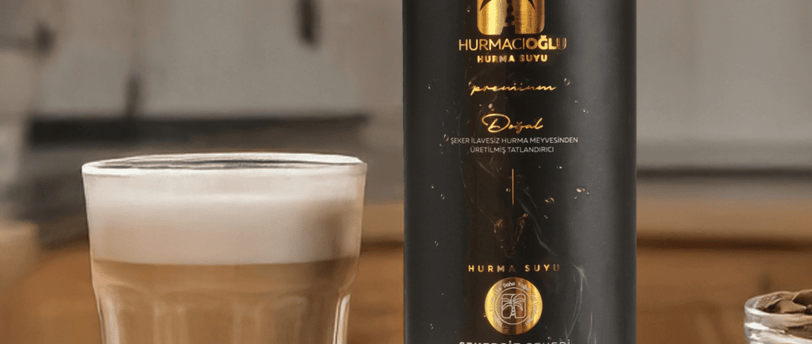 a bottle of coffee in a glass with a glass of hurmacioglu hurma suyu