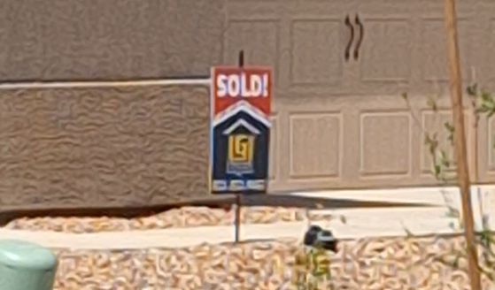 a sold sign in front of a garage door